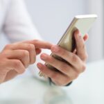 close-up-of-male-hands-using-smartphone-scaled